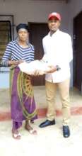 Our Project Leader giving 10kg rice to a widow