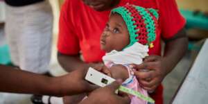 Child being measured with a MUAC Band