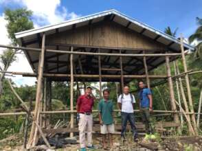 Farmer and OISCA staff in front of rearing house.
