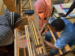 Weaving workshop participants warp a loom