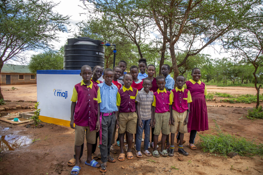 Kenyan children pose next to a kiosk in a school