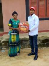 Project Leader giving food items to another widow