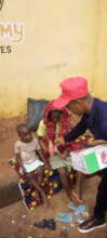 A child receiving food items for her mother