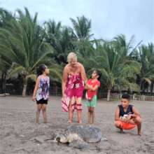 Nancy and children watching turtle lay her eggs