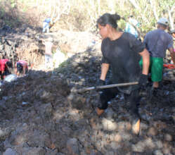 Woman digging canals for mangrove restoration