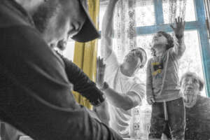 Everyone helps install window insulation