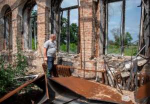 Andriy stands in the ruins of a school