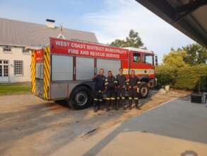 Firefighters on standby to defend a homestead