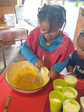 2 yo working with and making cake batter
