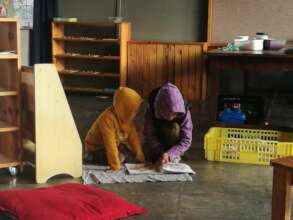 Seilin discussing pictures in a book with a peer