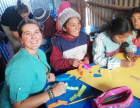 Volunteer teacher with the children in the village