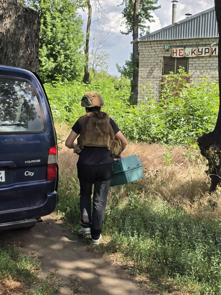 Dana in protective gear carries a rescued animal