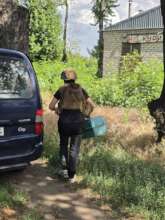 Dana in protective gear carries a rescued animal