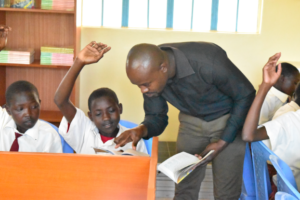 Mr. Okello helps one of his 7th grade students