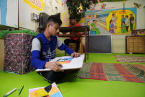 A boy studying in one of our open shelters