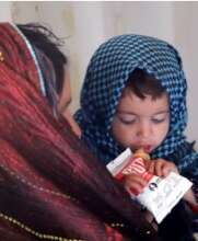 A child eats a RUTF packet at a health clinic