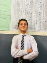 Student stands proudly in front of culture chart