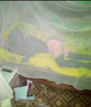 Joseph showing how he sleeps under his net