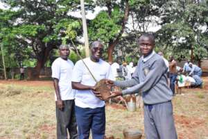Nicholas Muiya presenting seedlings to students.