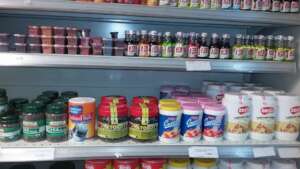 AF woman farmer, products at supermarket in city