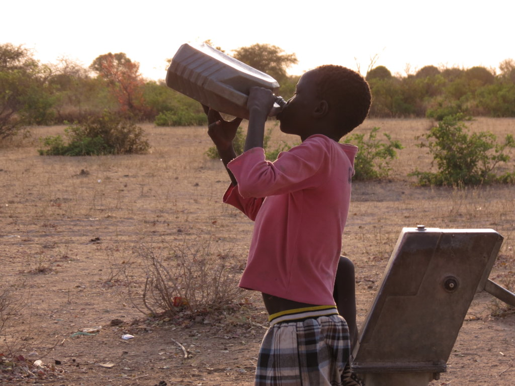 Child drinks water pumped from village well