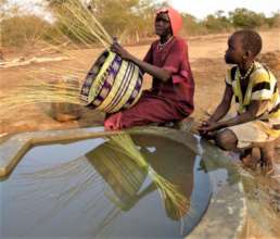 Women softening reeds at well