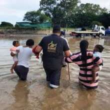 A displaced family navigates flooded streets