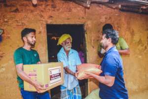 Our field team handing a rations pack to a farmer