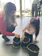 Kid planting in school bucket gardening program
