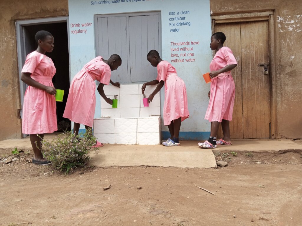 Pupils getting water from a water filter