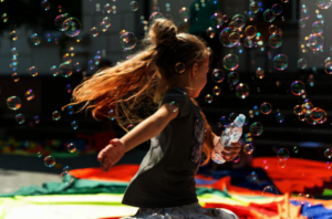 A refugee girl from Ukraine playing with bubbles
