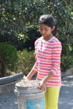 Student filling up a bucket from well