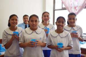 Girls holding cups of clean drinking water