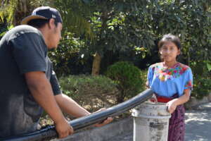 Girl filling up bucket of water