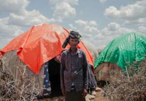 Makus standing outside of his tent.