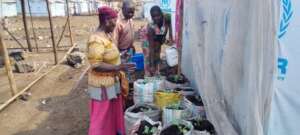 Women and their vegetable sacks in the refuge camp