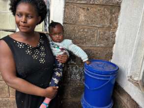 Agnes and her baby with their composting bin