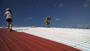 Volunteers work on roof preparation
