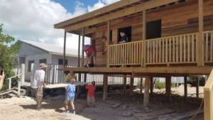 Volunteers installing sheetrock for inside rooms