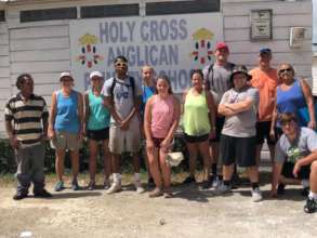 Volunteers pose at the entrance to the school