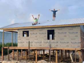 Volunteers celebrate after completing roof install