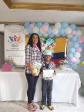 Graduated kid next to a teacher-volunteer