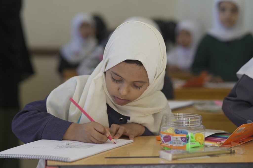 A girl focused on her drawing in class