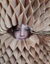 Misza looking through the paper toy