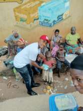 Our Project Leader giving food to a poor child