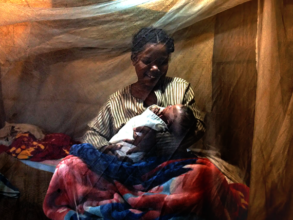 Mother Holding Her Child During a Househoold Visit