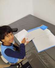 Karam smiles as he draws during a learning session