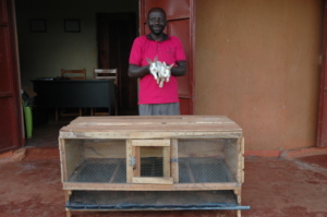 Farmer standing infront of a rabbit house