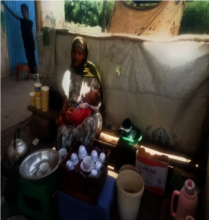 Biftu and her daughter at her coffee stand.