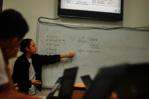 Teacher leads class activity: Basic Coding course.